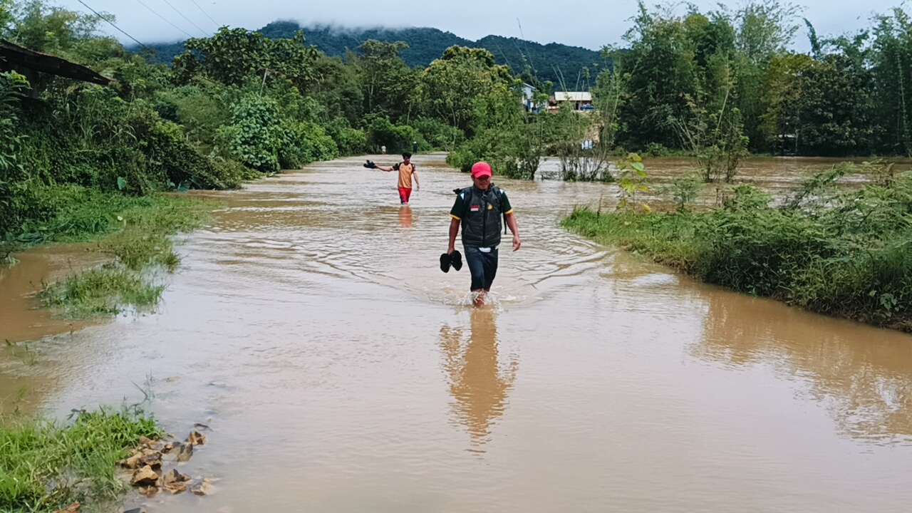 NEKAT : Masyarakat nekat melintas jalan yang terendam banjir untuk sampai di kantor agar tetap masuk bekerja.