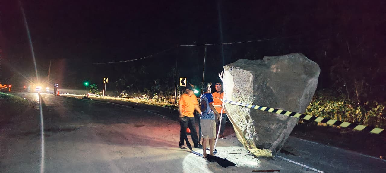 LONGSOR: Material batu berukuran besar menutup sebagian badan jalan.