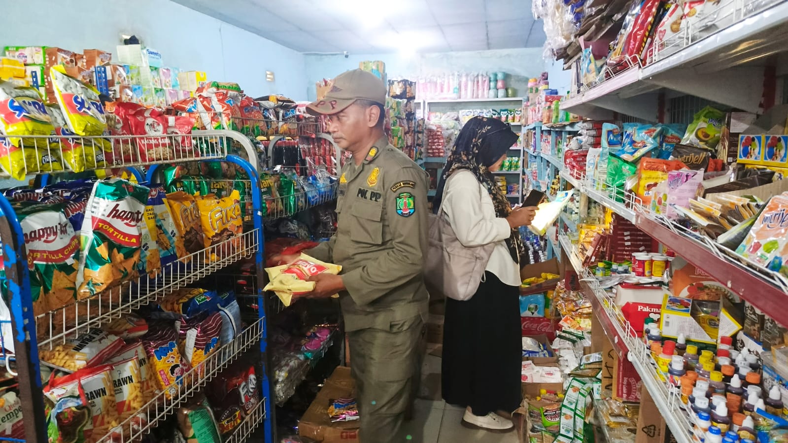 PEMERIKSAAN : Personel Pemerintah Kecamatan Sebatik, Satpol PP, serta tenaga kesehatan melakukan pengecekan makanan dan minuman yang terpajang di etalase.