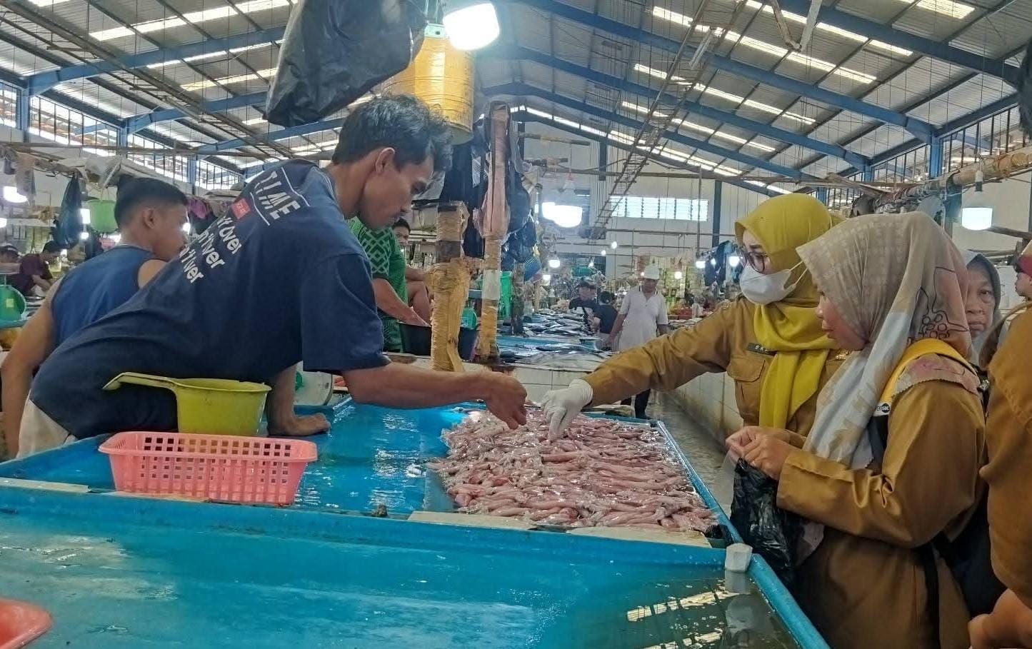 PEMERIKSAAN : Personel DKPP dan Dinas Perikanan Nunukan saat melakukan pengecekan sampel pangan segar di Pasar Yamaker.
