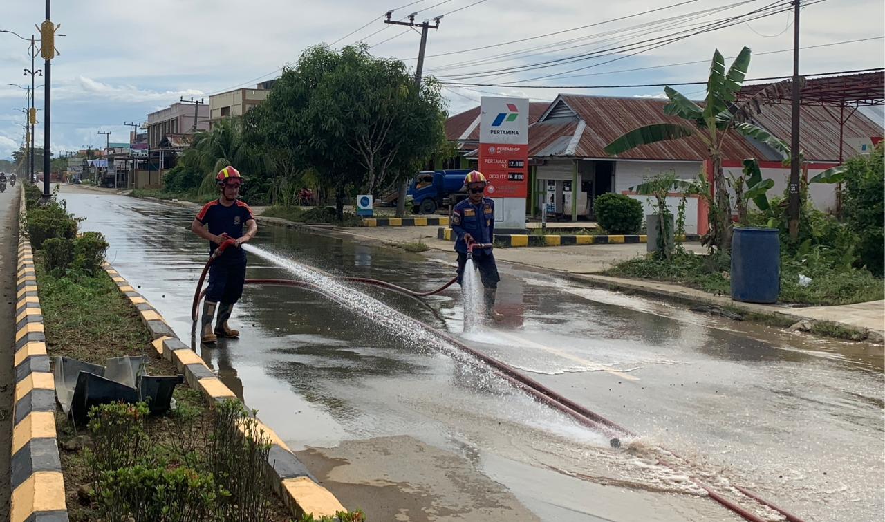 BERSIH: Damkar dan BPBD Malinau melakukan pembersihan jalan di seluruh rute jalan Malinau yang masih berlumpur dan tanah.