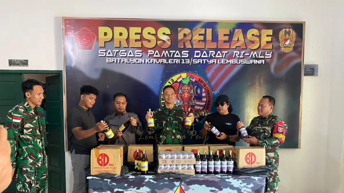 DIAMANKAN : Komandan Satgas Pamtas RI-Malaysia Yonkav 13/SL, Letkol Kav Ikhsan Maulana Pradana saat memperlihatkan miras ilegal yang diamankan personel gabungan TNI AD.&nbsp;