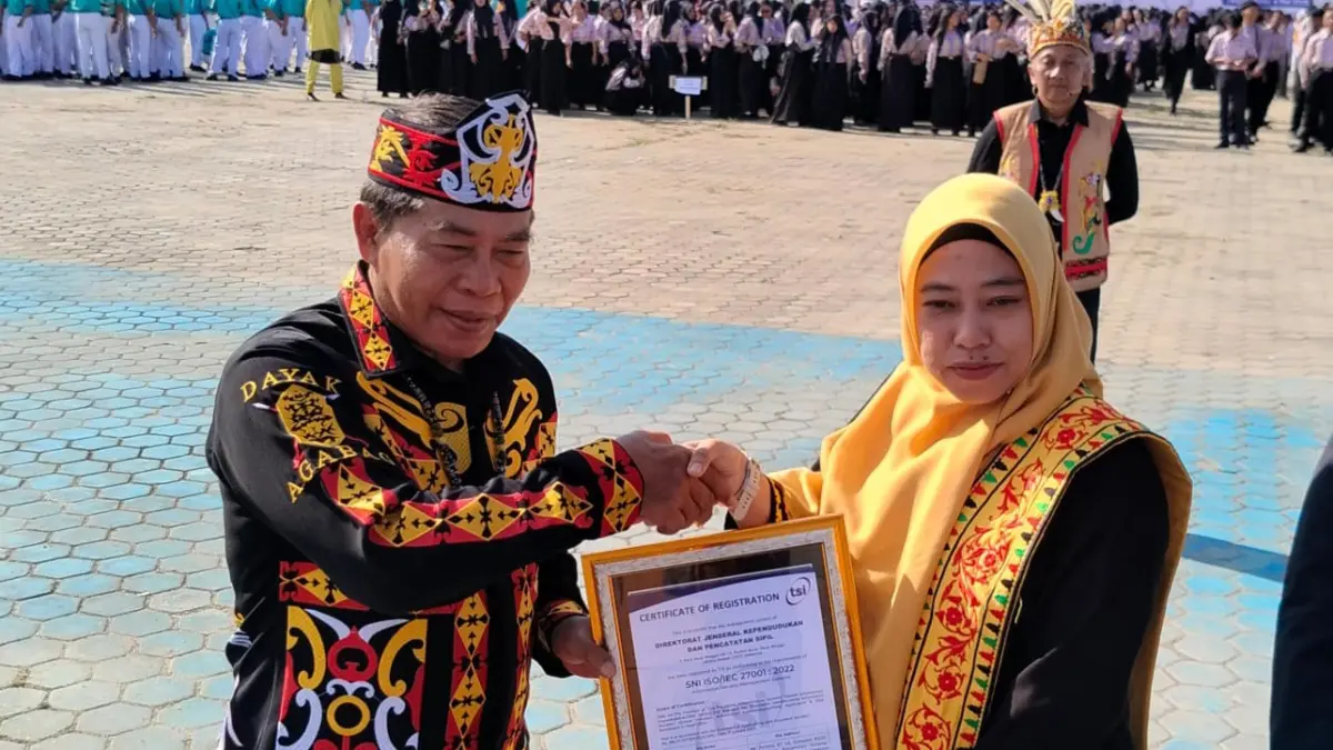 KEAMANAN DATA: Kepala Disdukcapil Tana Tidung Rahmawani terima sertifikat ISO/IEC 27001:2022, yang diserahkan Gubernur Kaltara H. Zainal Arifin Paliwang di momen Peringatan Hari Pendidikan Nasional yang digelar di lapangan Agatis Tanjung Selor, Senin (4/5).(FOTO: DOK DISDUKCAPIL KTT)