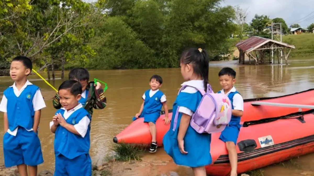 TERTAHAN : Kondisi jembatan yang terendam banjir membuat aktivitas siswa-siswi, masyarakat dan perkantoran tertahan.&nbsp;