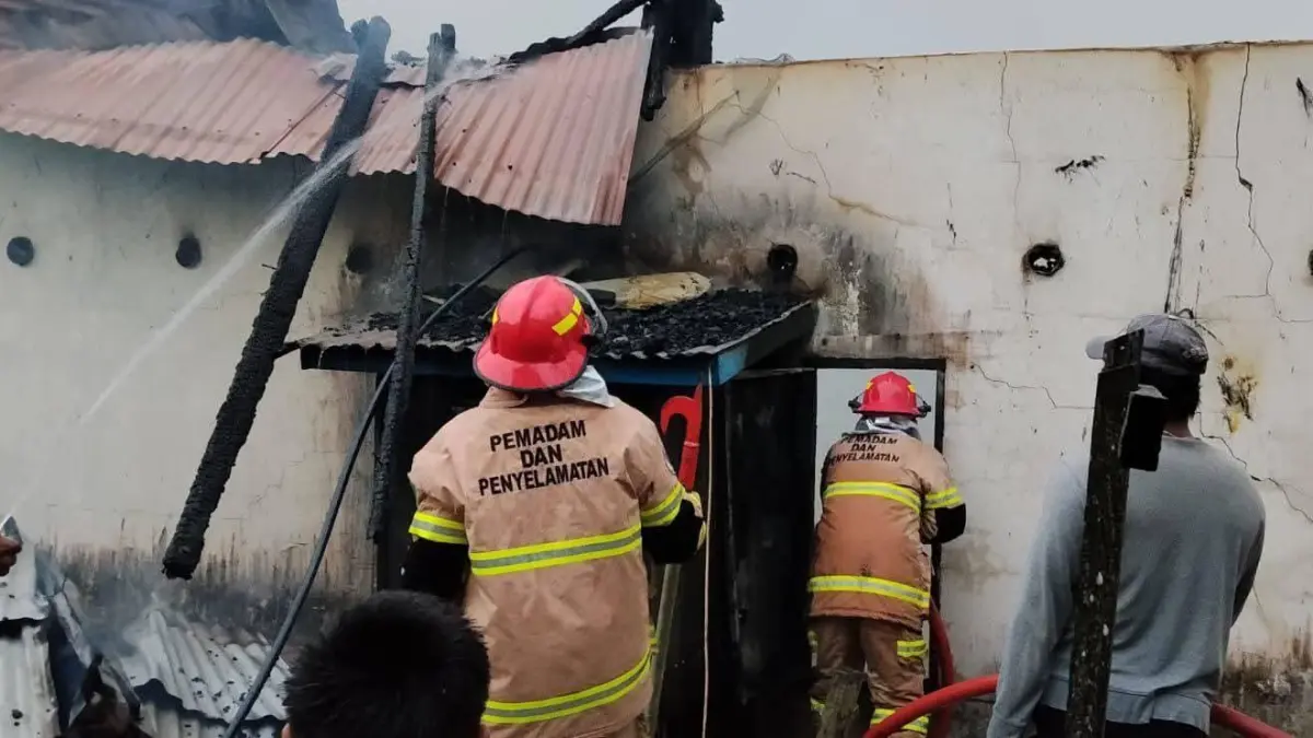 PENDINGINAN : Personel Damkar Nunukan melakukan pendinginan atas rumah walet yang terbakar di Jalan Dewi Sartika RT 08 Sei Lancang Kelurahan Nunukan Selatan.&nbsp;