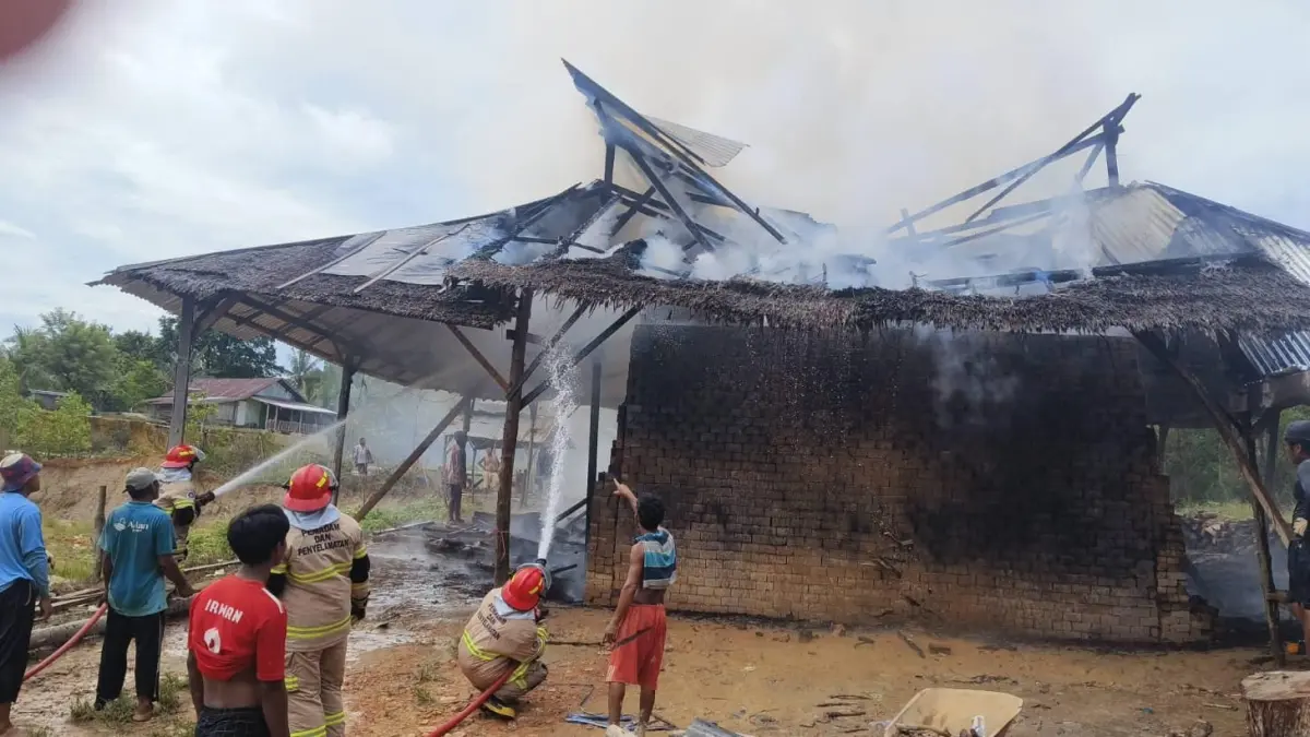 BERJIBAKU : Personel Damkar Nunukan saat melakukan pemadaman di rumah produksi batu bata merah yang terbakar.&nbsp;