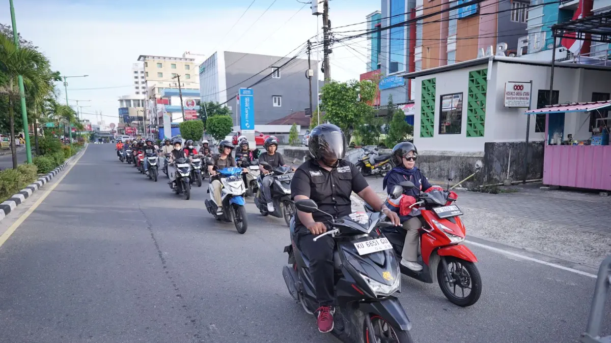 Peserta touring sepeda motor Honda berkendara dengan formasi tertib di jalan raya sebagai bagian dari kampanye keselamatan berkendara (safety riding).