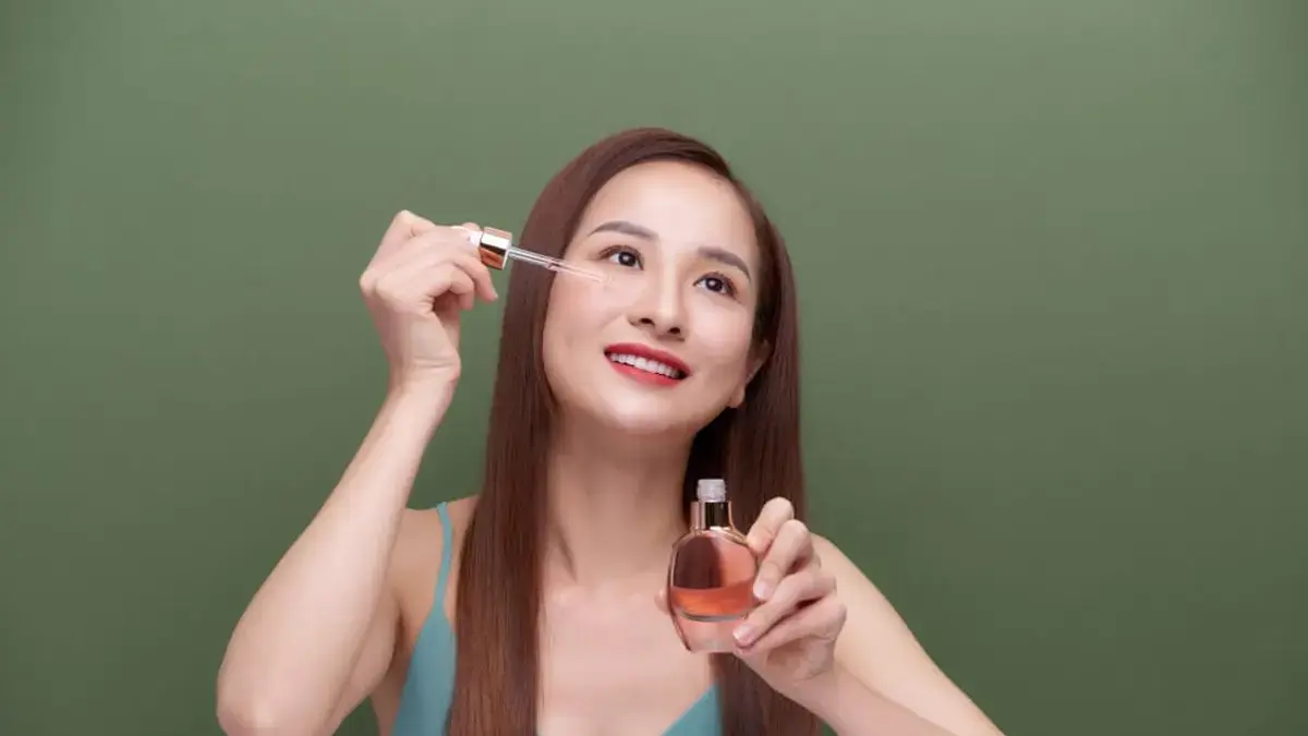 Ilustrasi penggunaan serum yang diperagakan model. 