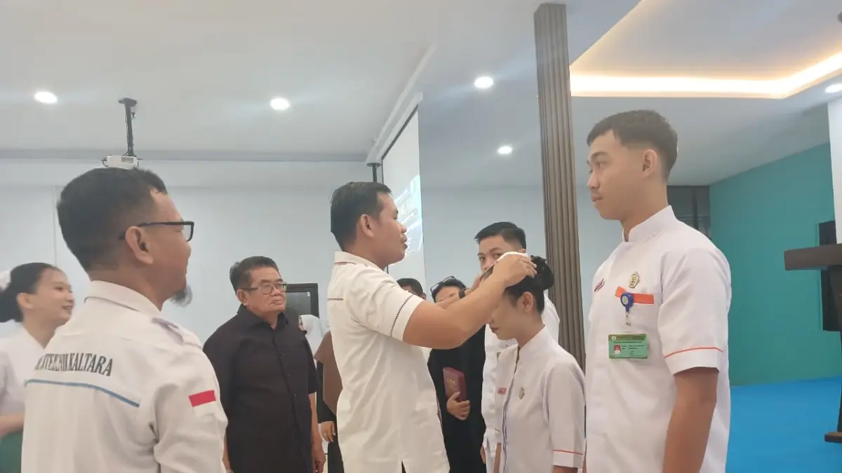 DIPASANG : Dosen memasangkan cap pada mahasiswa yang hendak dilepas bertugas di Fasilitas Kesehatan