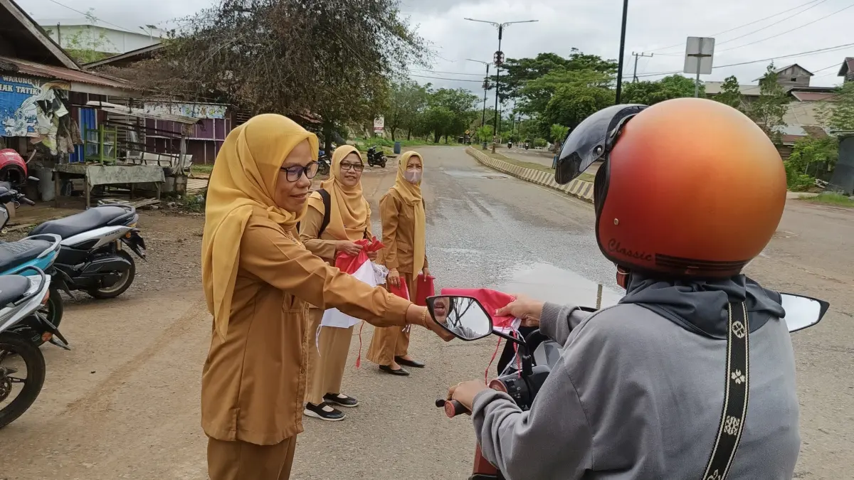 GERAKAN BENDERA: ASN Bagian Organisasi Sekretariat Tana Tidung membagikan bendera kepada pengendara di Tideng Pale.(FOTO: DOK BAGIAN ORGANISASI)