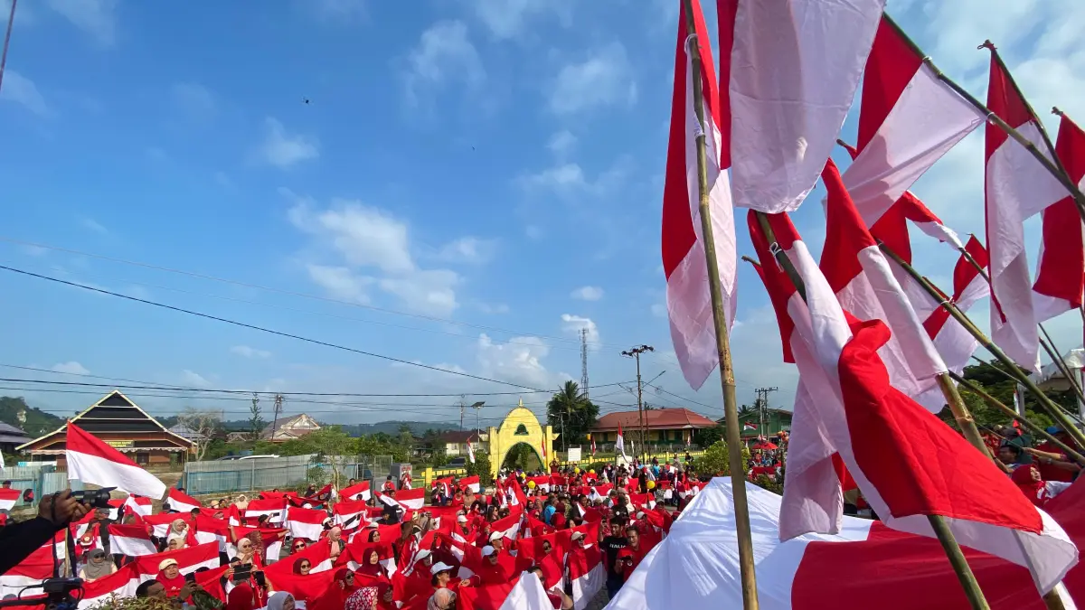 MERAH PUTIH BERKIBAR: Ribuan warga mengibarkan bendera merah putih dan membentangkan bendera saat mengikuti kegiatan gerakan pembagian bendera merah putih di Bulungan, Sabtu (2/8).
