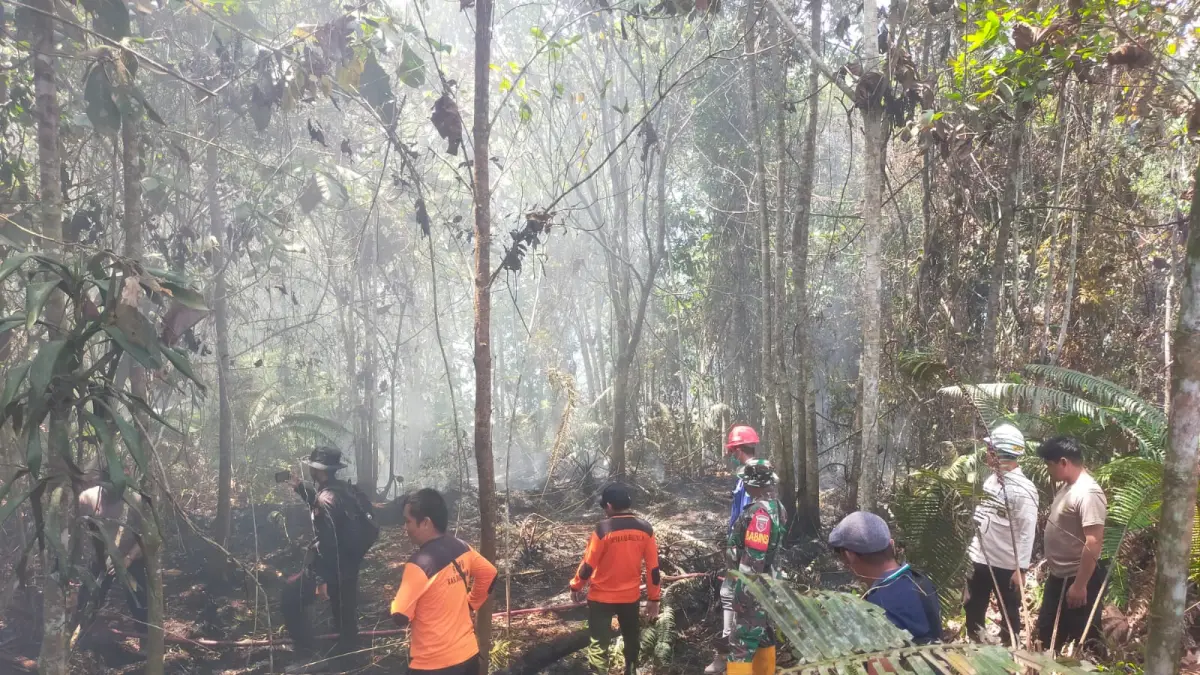 KARHUTLA : Petugas gabungan melakukan menyemprotkan air ke area yang masih mengeluarkan asap untuk mencegah api kembali membesar dan meluas ke kawasan sekitar.