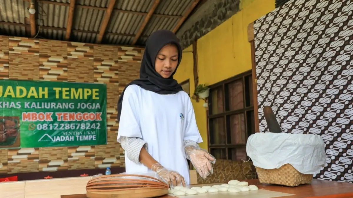 Seorang pelaku usaha tengah menyiapkan adonan tempe di kawasan Kaliurang, Yogyakarta.