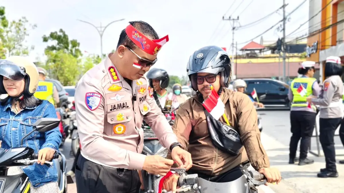 BAGI BENDERA : Dirlantas Polda Kaltara Kombes Pol Jamal Alam membagikan bendera merah putih kepada pengendara saat kegiatan Polantas Karib di wilayah Bulungan. 
