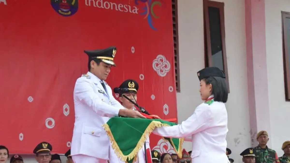 KHIDMAT : Bupati Nunukan, H. Irwan Sabri saat menyerahkan bendera merah putih kepada Paskibra yang bertugas di Krayan.&nbsp;