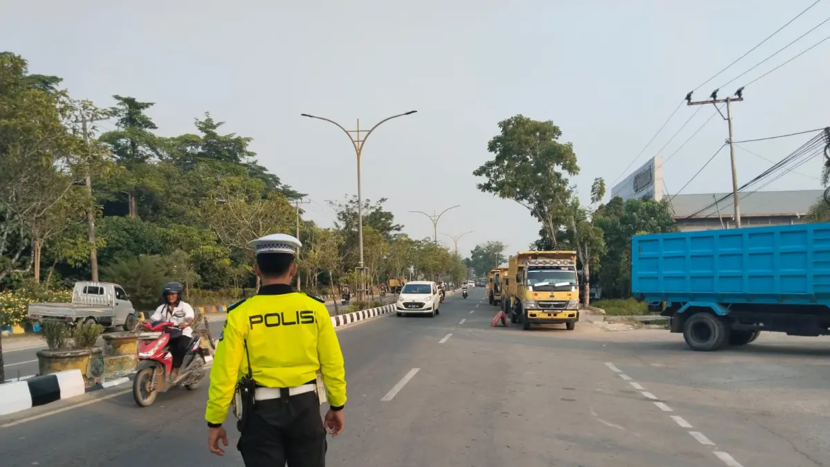 PENGATURAN LALU LINTAS : Personel Satlantas mengatur arus lalu lintas di area SPBU Jalan Sengkawit.