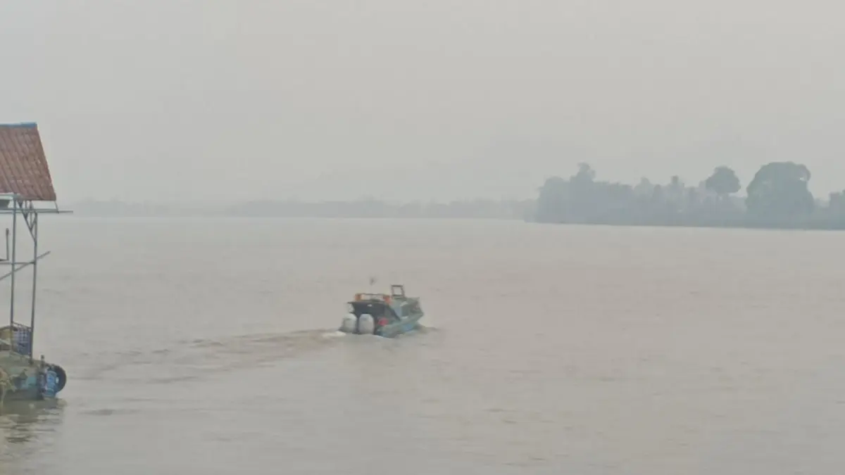 KABUT ASAP : Speedboat berlayar di tengah kabut asap di wilayah Tanjung Selor.