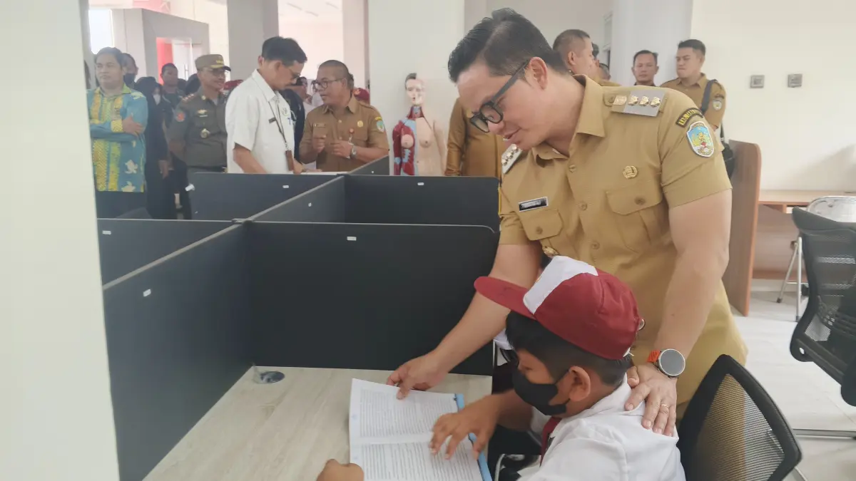 BELAJAR DARI RUMAH: Bupati Ibrahim Ali menyapa murid SD yang sedang membaca di Perpusda pasca meresmikan. FOTO: SOPIAN/RADAR TARAKAN