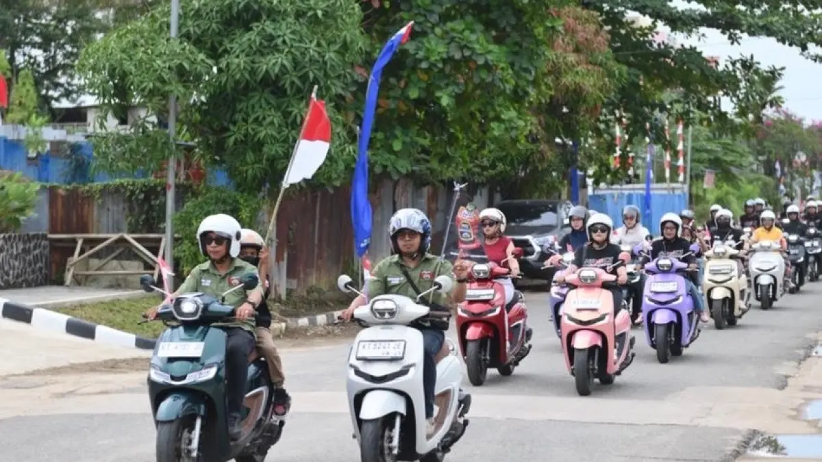 Rombongan peserta mengikuti konvoi sepeda motor melintasi jalan kota dengan membawa semangat kebersamaan dan nuansa perayaan kemerdekaan Indonesia.
