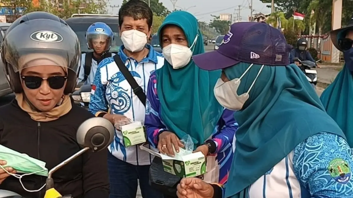
MITIGASI : Ketua TP PKK Bulungan, Sri Nurhandayani membagikan masker kepada pengendara yang melintas.
