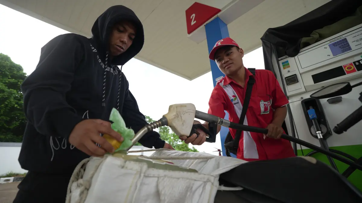 DIAWASI : Petugas SPBU di Tanjung Palas mengisi BBM ke dalam jeriken.