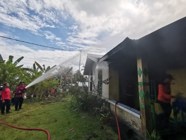 MEMADAMKAN API: Sejumlah personel Disdamkar saat berusaha memadamkan api yang sudah terlanjur melahap rumah Suardi, Minggu (13/2). (Riko Aditya/Radar Tarakan) 