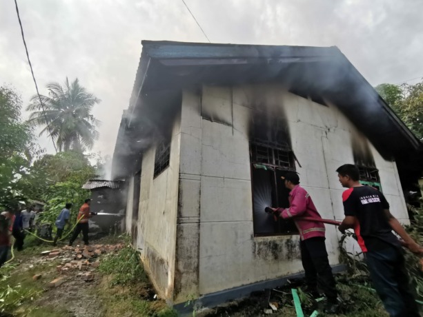 DIPADAMKAN: Sejumlah personel  Disdamkar masih berusaha memadamkan api yang membara.