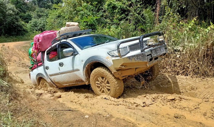 MEDAN BERAT: Rusaknya jalan dari Long Bagun menuju Apau membuat angkutan bahan pokok masyarakat susah didapat. Mobil dobel gardan hampir terbalik saat melewati jalan di Apau Kayan, Kamis (14/3) lalu. (FOTO: AGUSSALAM SANIP/RADAR TARAKAN)