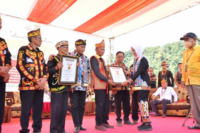 RAIH TIGA MURI: Bupati Nunukan Hj. Asmin Laura Hafid. SE. MM Ph.D saat menerima piagam MURI.