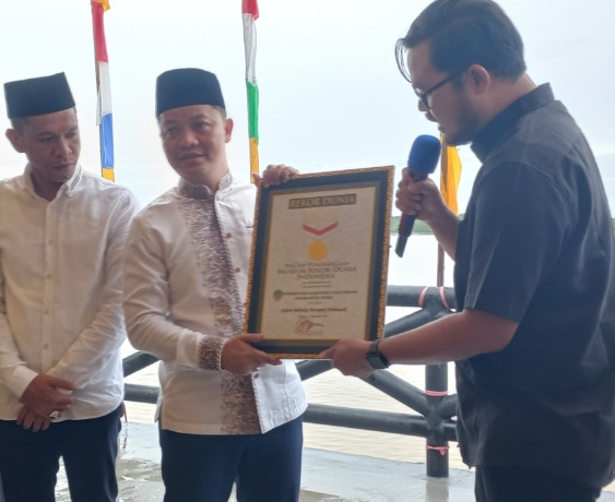 REKOR LAGI: Bupati Tana Tidung Ibrahim Ali menerima piagam MURI berkat penyajian ketupat terbanyak.(Foto: Sopian Hadi/Radar Tarakan)