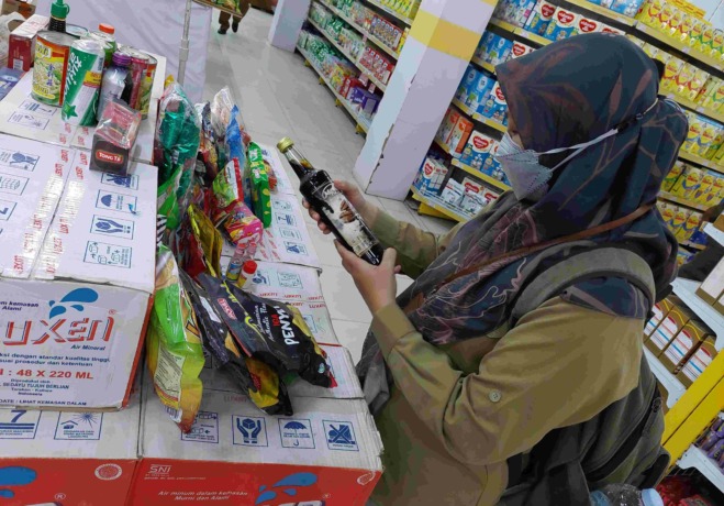 (PIJAI PASARIJA/RADAR KALTARA) PEMERIKSAAN: Petugas saat memeriksa masa kedaluwarsa produk minuman di salah satu minimarket di Tanjung Selor.