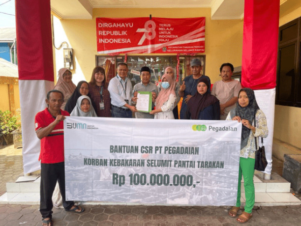 Kepala Departemen Gadai, PT Pegadaian Area Tarakan, Muhammad Darjat serta perwakilan korban kebakaran saat foto bersama usai dilakukan penyerahan simbolis bantuan untuk korban kebakaran di halaman Kelurahan Selumit Pantai, Jumat (12/8)