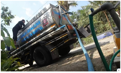 DISTRIBUSI: Petugas Tagana Dinas Sosial saat menyalurkan air bersih. (Guntur Aga Tirtana/Radar Jogja)