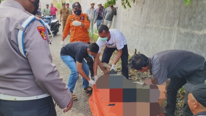 Polisi evakuasi dan olah TKP di lokasi penemuan mayat di area pekarangan Gedung Serbaguna (Paluta), tepatnya, di saluran pembuangan air Kantor Dinas Sosial Paluta, Selasa (2/1). (Samman/MetroDaily)