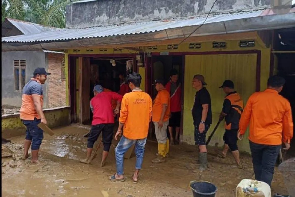 Tim BPBD membantu membersihkan material banjir di rumah warga.