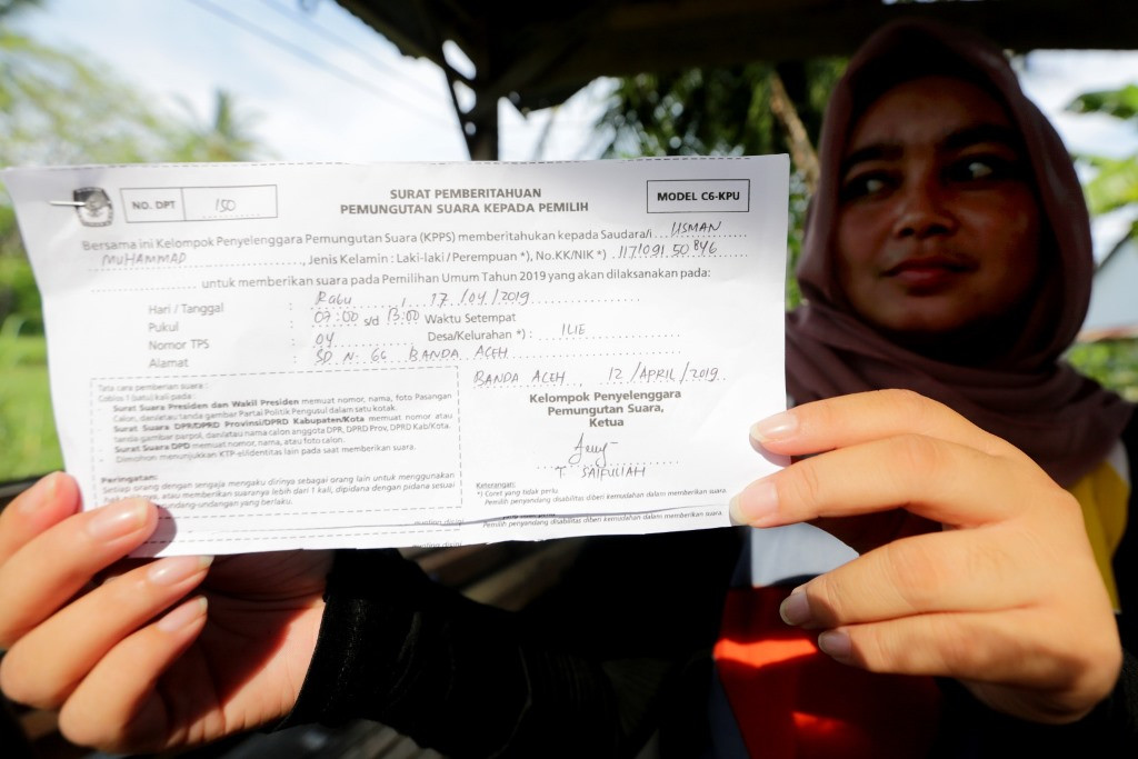Seorang warga memperlihatkan contoh surat undangan memilih atau yang dikenal namanya formulir model C6 dari KPU.