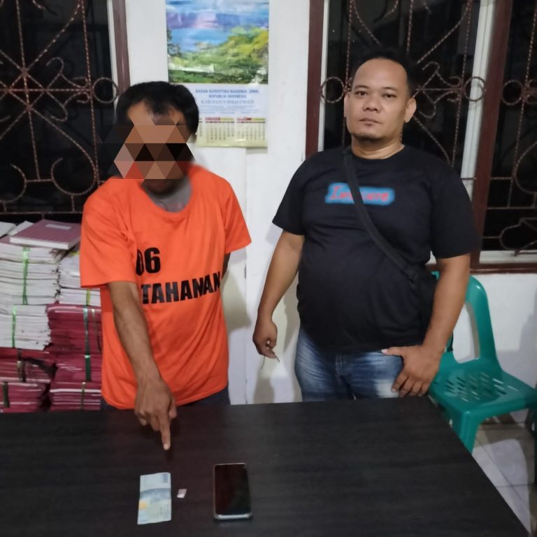 Tersangka (baju kuning) menunjukkan barang bukti.