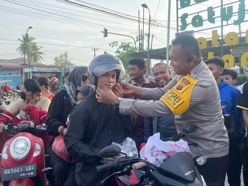 Kapolres Tanjung Balai AKBP Yon Edi Winara memberikan helm kepada pengguna jalan.
