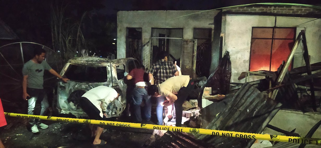Polisi saat melakukan olah TKP di depan rumah Junaidi Marpaung.