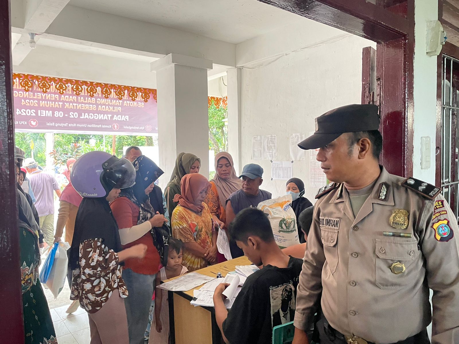 Personil Polres Tanjungbalai mengamankan pembagian beras cadangan.