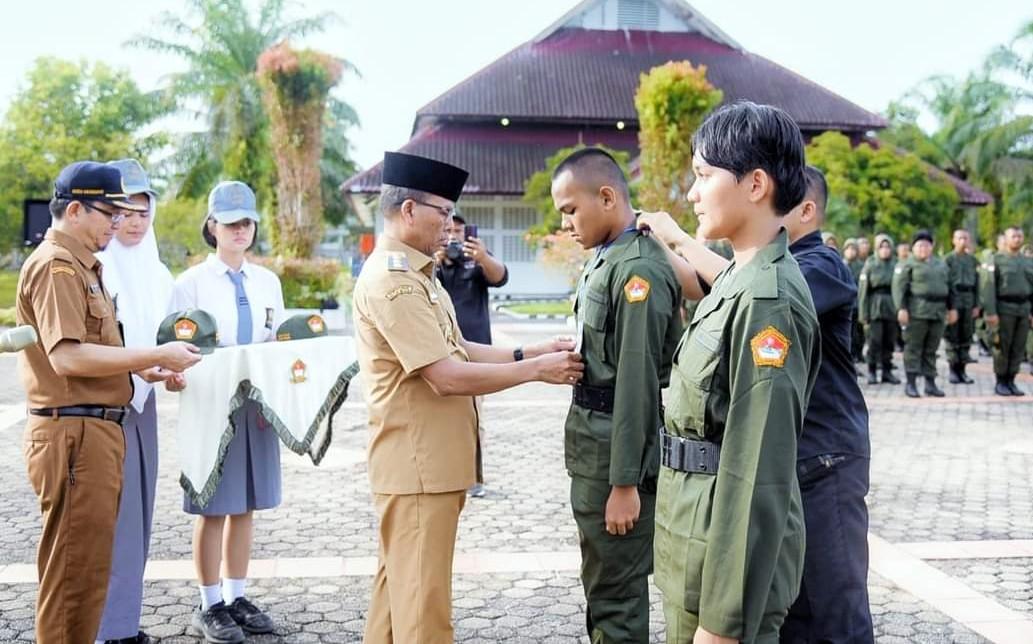 Pj Bupati Tapteng, Sugeng Riyanta didampingi Kepala SMAN 1 Pandan, Deden Rachmawan saat menyematkan atribut pada Apel MPLS bagi siswa baru SMAN 1 Matauli Pandan.