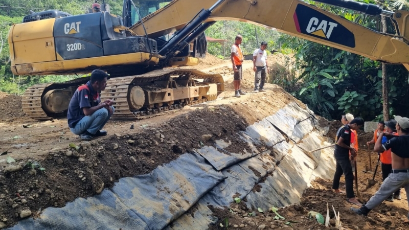 Pekerja dibantu alat berat mengerjakan penimbunan badan jalan di lokasi yang sebelumnya terpasang jembatan bailey di Jalan Sibolga-Tarutung via Batu Lubang.