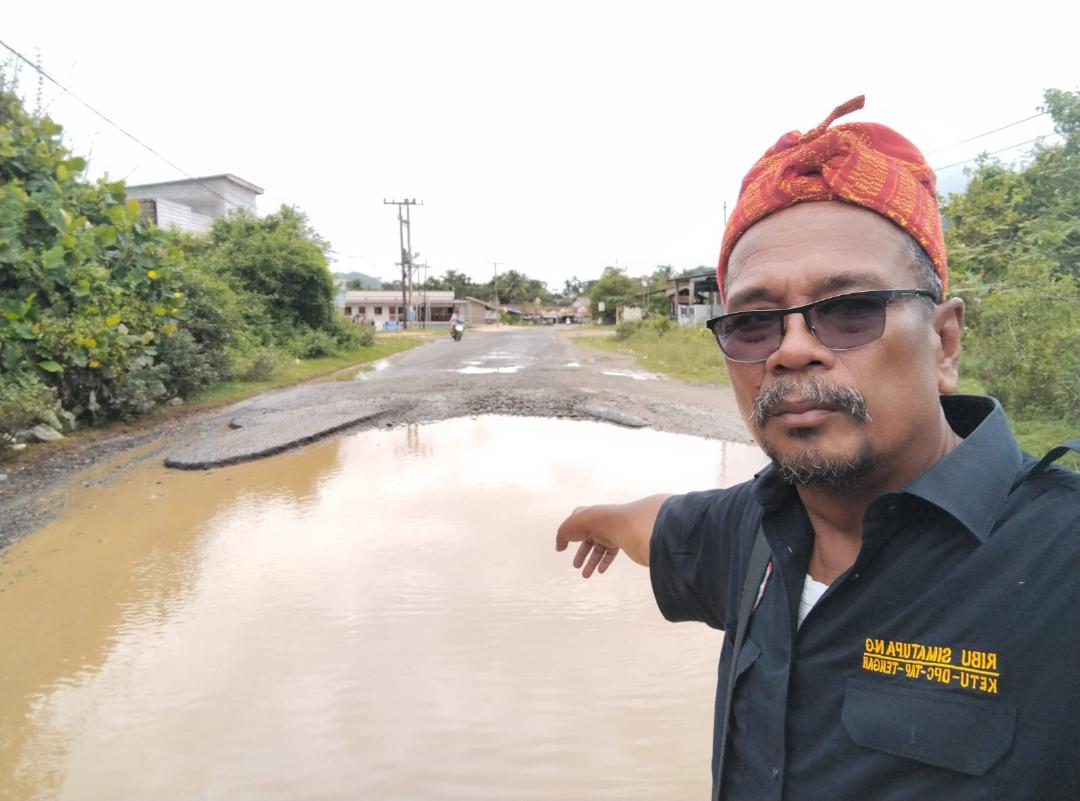 Ribu Simatupang menunjuk Jalan Tugu Ikan-Abdul Rajab Simatupang yang rusak parah.