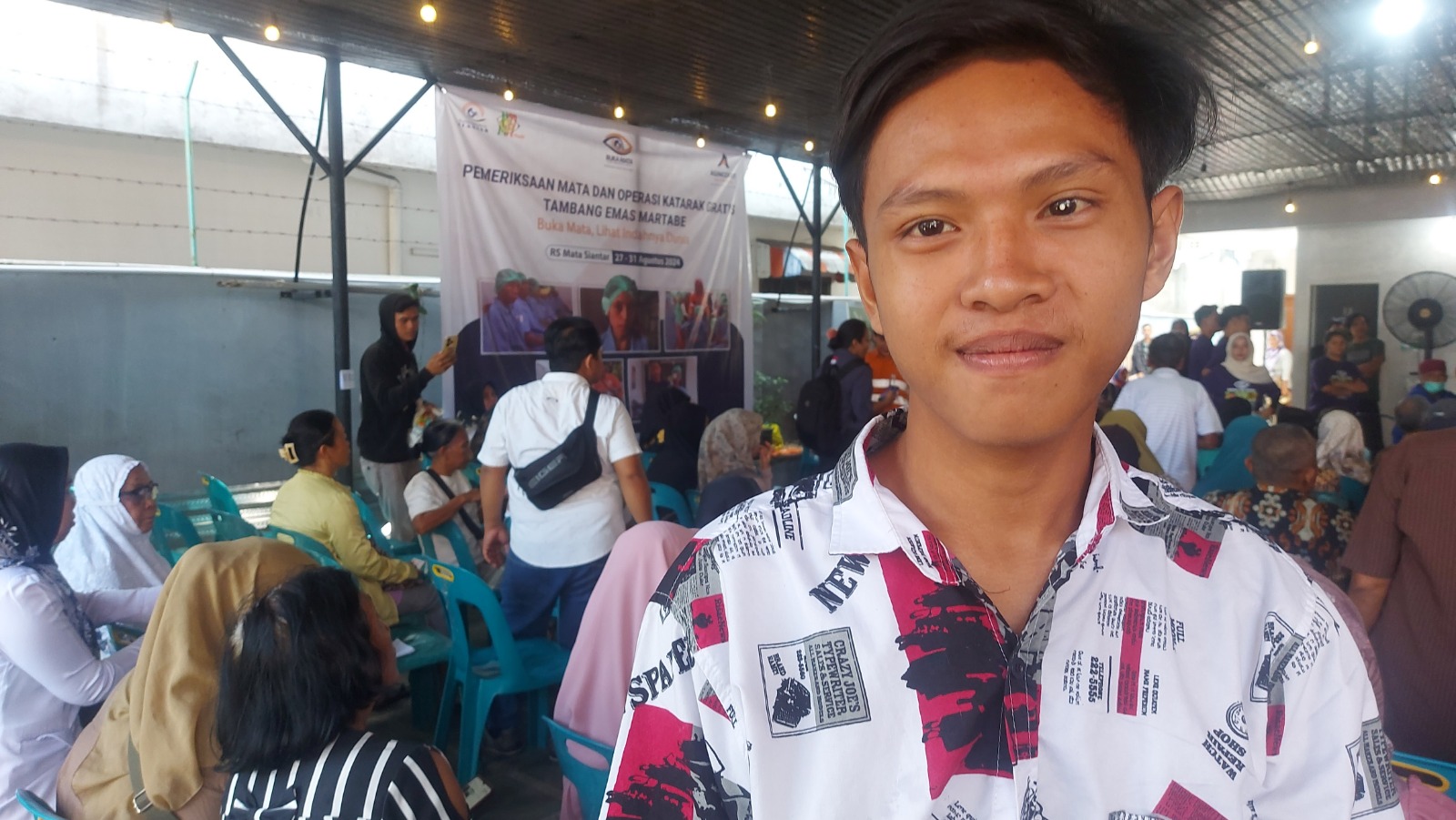 Aril Gunawan, pemuda 19 tahun penderita katarak, menunggu giliran pada Operasi Katarak Gratis 2024 yang digelar PT Agincourt Resources di RS Mata Siantar, Rabu (28/8/2024).