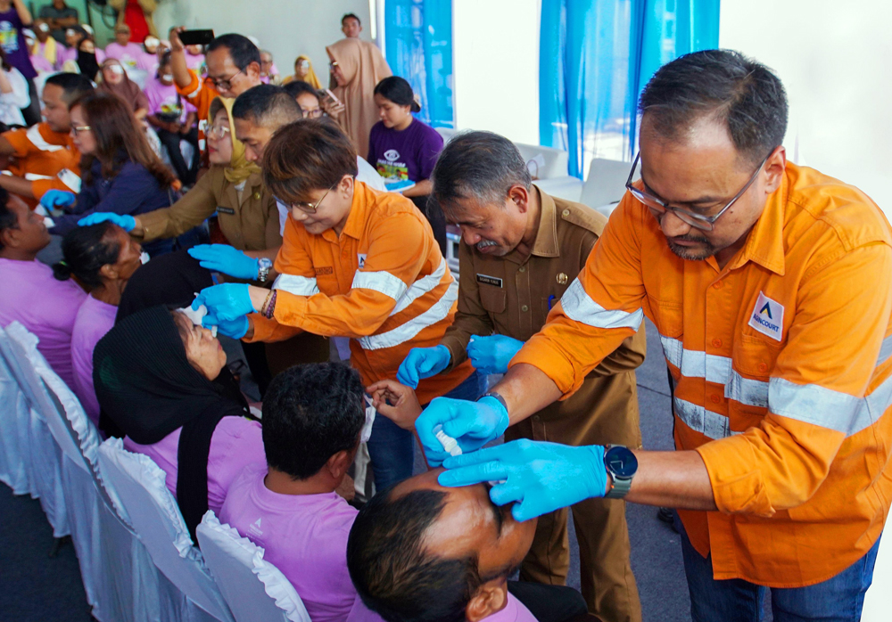 Director & CFO PT Agincourt Resources (PTAR) Noviandri (kanan) meneteskan obat mata ke pasien yang telah menjalani operasi katarak saat penutupan operasi katarak gratis 2024 Tambang Emas Martabe.