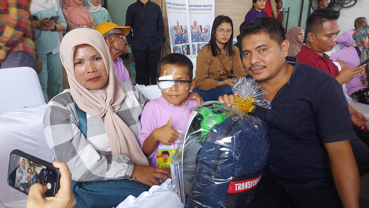 Mustofa Harahap, 9 tahun (tengah), dikawal awah dan ibunya usai menjalani operasi katarak gratis yang digelar PT Agincourt Resources di RS Mata 77 Medan, Senin (9/9/2024).