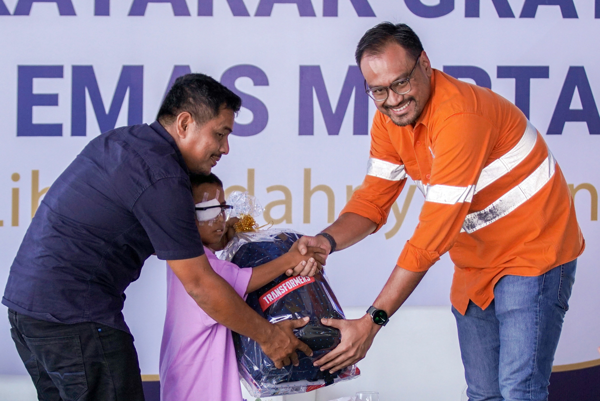 Director & CFO PT Agincourt Resources Noviandri (kanan) menyerahkan bingkisan berupa alat tulis dan bola kepada Mustofa Harahap, 9 tahun (tengah), yang baru menjalani operasi katarak, Senin (9/9/2024)