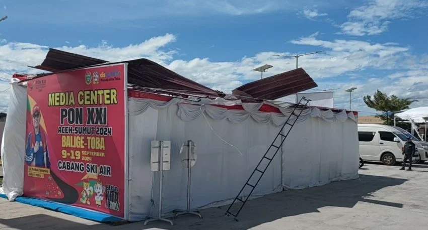 Atap Media Center PON XXI Cabor Ski Air terbang ditiup angin.