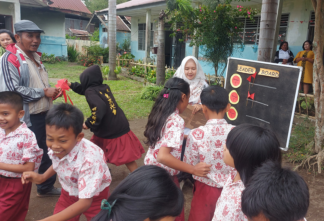 Muri Rasika memandu anak-anak kelas 5 SDN 044826 Samura Kecamatan Kabanjahe, Kabupaten Karo, belajar perkalian dan pembagian bilangan cacah lewat metode pembelajaran berbasis gamifikasi.