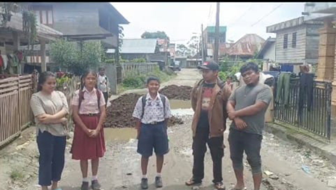 Tim TOSS menimbun jalan yang rusak.